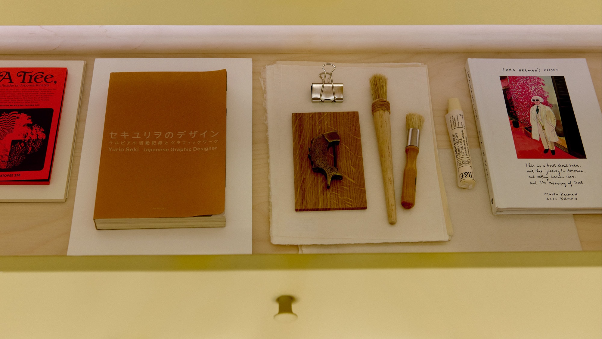 paper and paintbrushes in a drawer that’s been pulled out